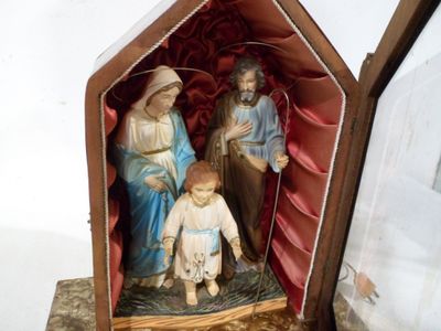 une statue d'un homme et d'une femme avec un enfant dans une boîte