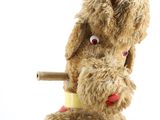 a stuffed dog that is holding a cigarette in its mouth