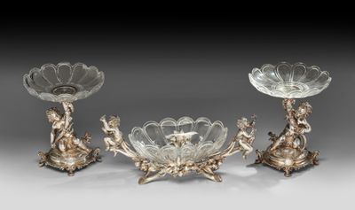 trois bougeoirs en métal plaqué argent, ornés de fleurs et de feuilles