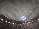 a close up of a black purse with a blue label on it