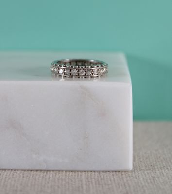 une photo d'une bague en diamant posée sur un bloc de marbre