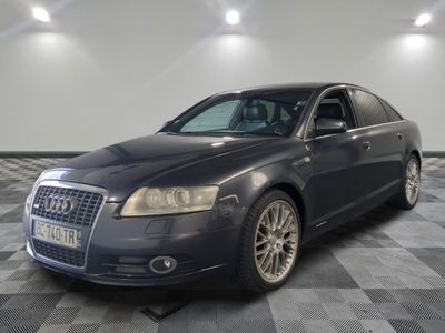 une photo d'une voiture de couleur sombre garée dans un garage