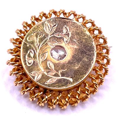 an image of a gold colored broochle with a stone in the center
