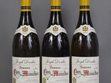 three bottles of wine are lined up on a table