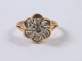 a close up of a gold and diamond flower ring