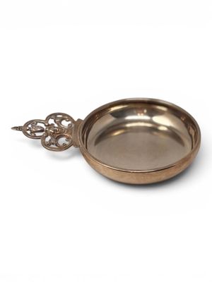a close up of a metal bowl with a handle on a white background