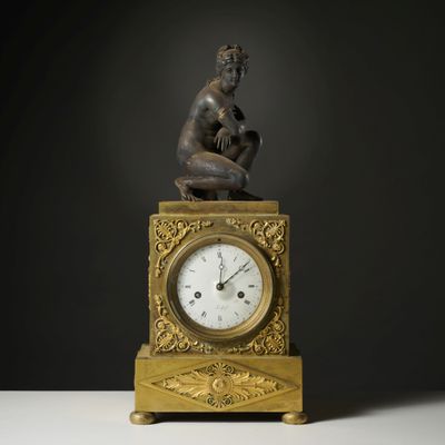 a statue of a man sitting on top of a clock