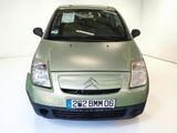 a small green car parked in a white room