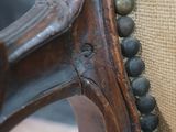 a close up of a wooden chair with beads on it