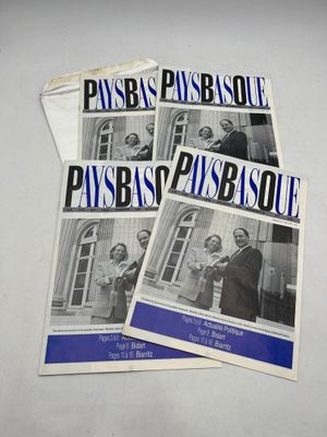 une pile de brochures avec des photos de personnes devant un immeuble