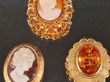 trois broches de couleur or ornées de camées représentant une femme et un homme