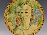 a plate with a painting of a woman on it
