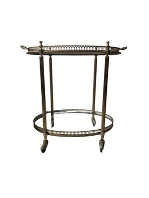 a brass bar cart with a glass shelf on wheels