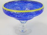a blue glass bowl with a yellow rim sitting on a table