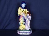figurine représentant une femme tenant un enfant dans ses bras, sur fond bleu