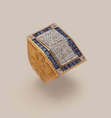 a close up of a gold and diamond ring with blue sapphires