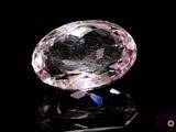 a close up of a pink diamond on a black surface