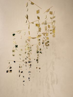 une sculpture composée de carrés dorés et noirs sur un mur blanc