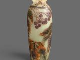 an image of a vase with leaves and berries painted on it