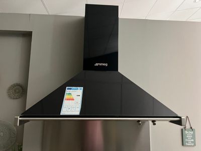 une plaque de cuisson noire sur laquelle est posé un smartphone
