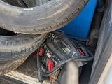 two tires in the back of a truck with a blue container