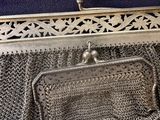 a silver purse that is sitting on a table