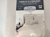 emballage d'un lit sur lequel est posée une couette blanche