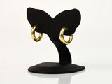 une paire de boucles d'oreilles créoles en or posées sur un support noir, sur fond blanc