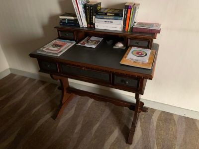 un petit bureau sur lequel sont posés de nombreux livres