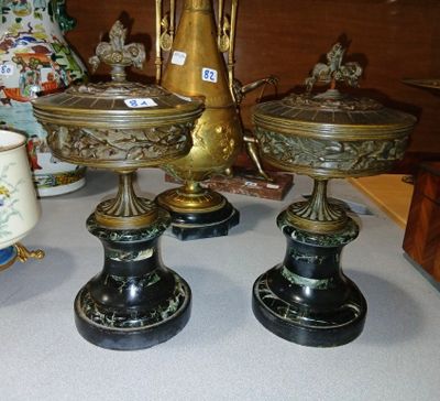 three vases on a table with a gold vase in the background
