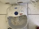 someone standing next to a washing machine on a tiled floor next to a pair of red shoes