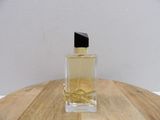 an image of a bottle of perfume sitting on top of a wooden table