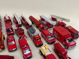 a lot of toy firetrucks and trucks on the table