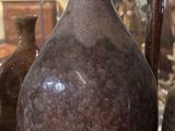 many vases that are on display in a glass case
