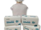 une personne portant un masque à côté de trois boîtes de masques
