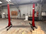 un garage avec deux ponts élévateurs rouges au milieu