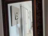 un miroir sur le mur au-dessus d'un lavabo dans une salle de bains