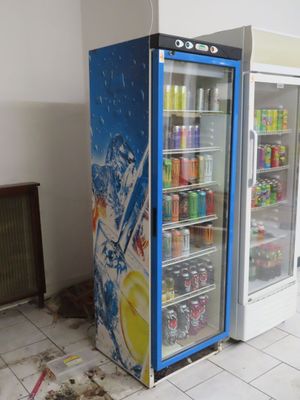 two refrigerators that are sitting in the middle of a room