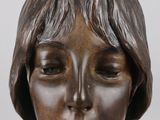 bronze sculpture of a woman ' s head with eyes closed