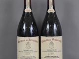 deux bouteilles de vin rouge sont posées sur une table en verre