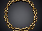 a gold chain bracelet with links on a black background