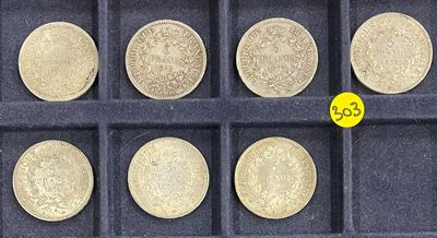 six different types of coins in a display case with a yellow coin