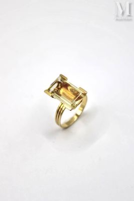 a close up of a gold ring with a green tourmaline stone
