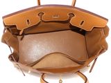 the inside of a brown and tan purse on a white surface