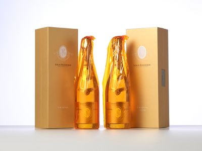 two bottles of champagne sitting next to each other in front of a box