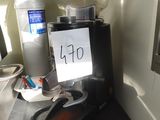 une cafetière posée sur un plan de travail, sur laquelle est accrochée une pancarte