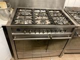 two stoves that are in a kitchen with pots on the counter