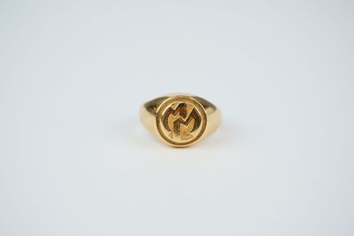 a close up of a gold ring on a white surface