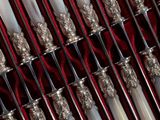 many toothbrushes lined up in a row on a red cloth