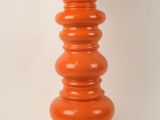 an orange table lamp with a white shade on top of it